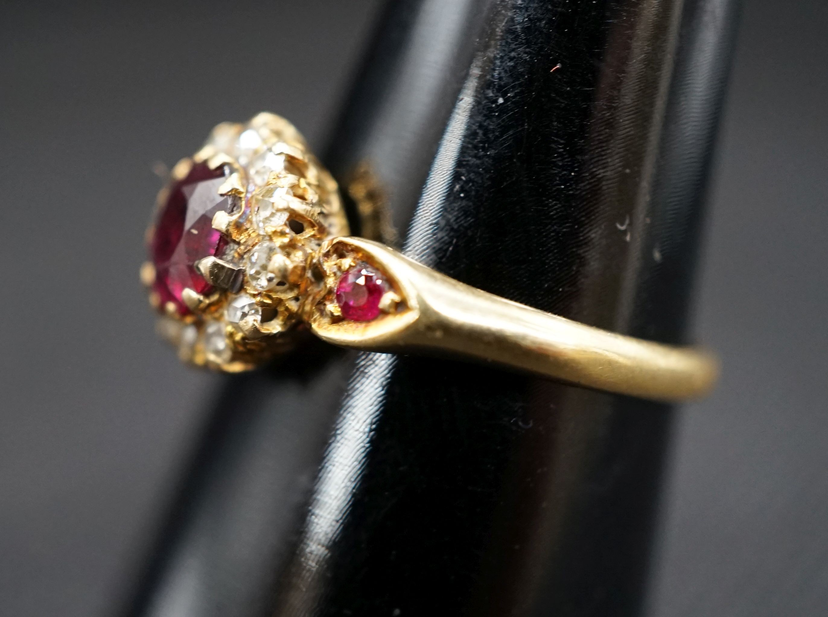 A late Victorian 18ct gold ruby and diamond cluster ring, with ruby set shoulders, size M, gross weight 2.7 grams.